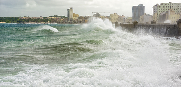 A storm surge attacks a seawall that protects a coastal city.