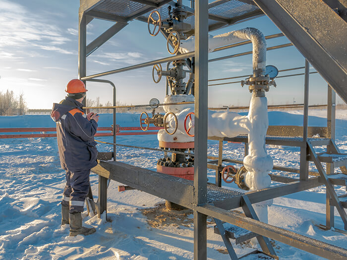 An operator services an oil well in the northern oil field in winter