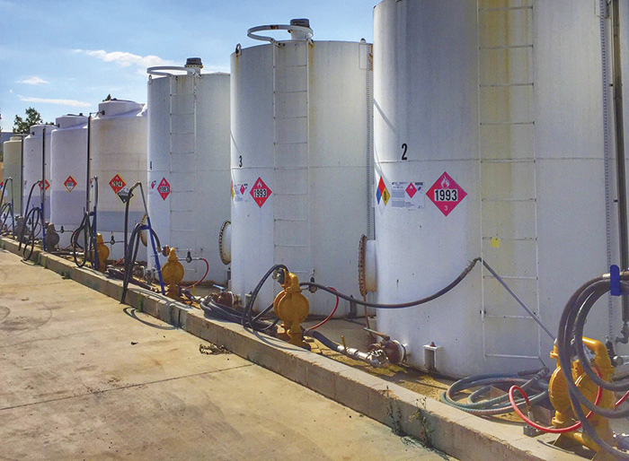 A group of pumps installed next to outdoor chemical tanks