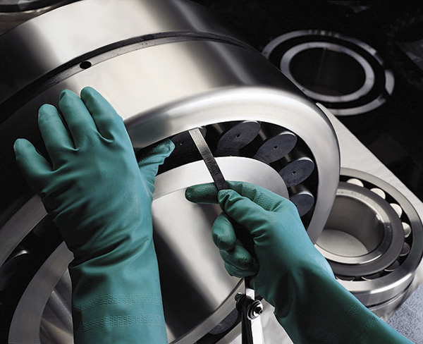 A worker files a bearing as part of a remanufacturing process as an alternative to bearing replacement.