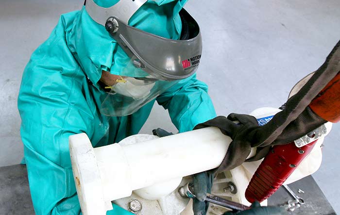 A service technician removes an AODD’s manifold bolts