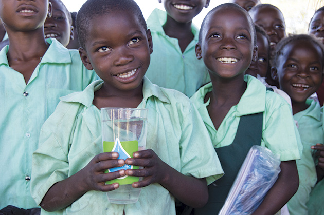 Children at Kafwikamo Community School show off clean water from the LifePump.