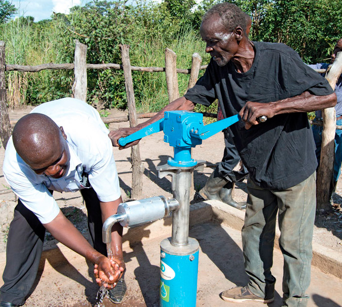 An elderly Zambian man pumps water from the LifePump.