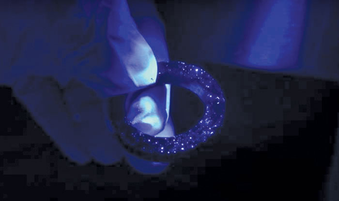 Packing ring under UV light showing particulate contamination