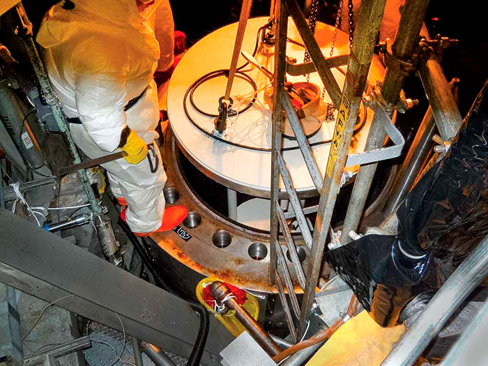 a field engineer places a foreign material exclusion shield over the pump housing