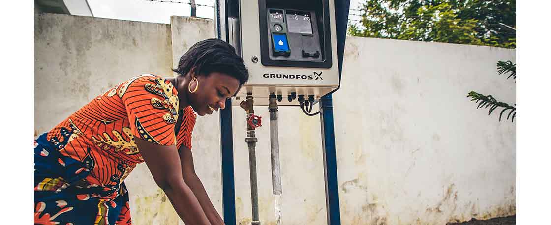 woman purchases water from water dispenser