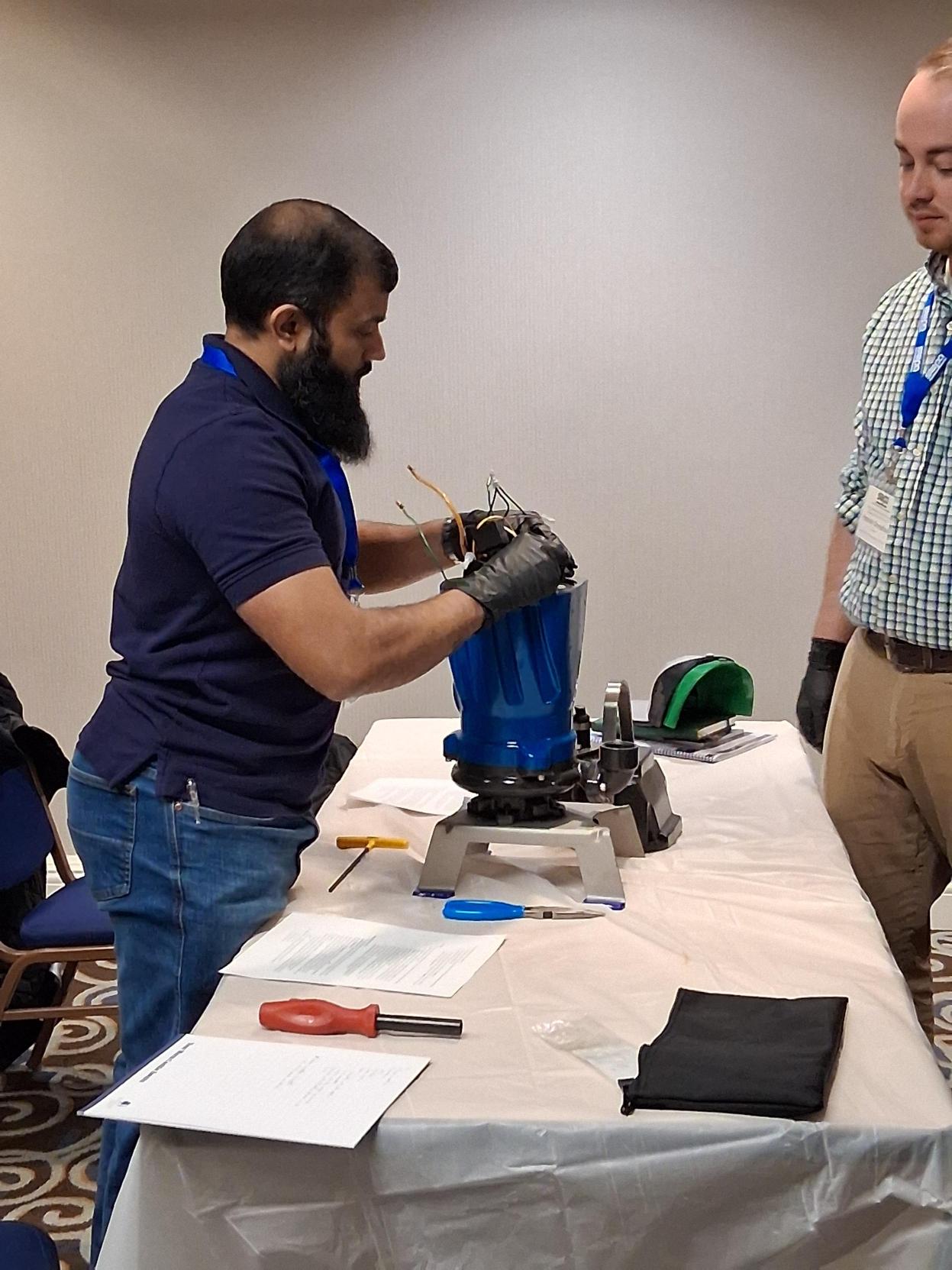 Image 4: Seminar attendees work at disassembling a pump (cont.)