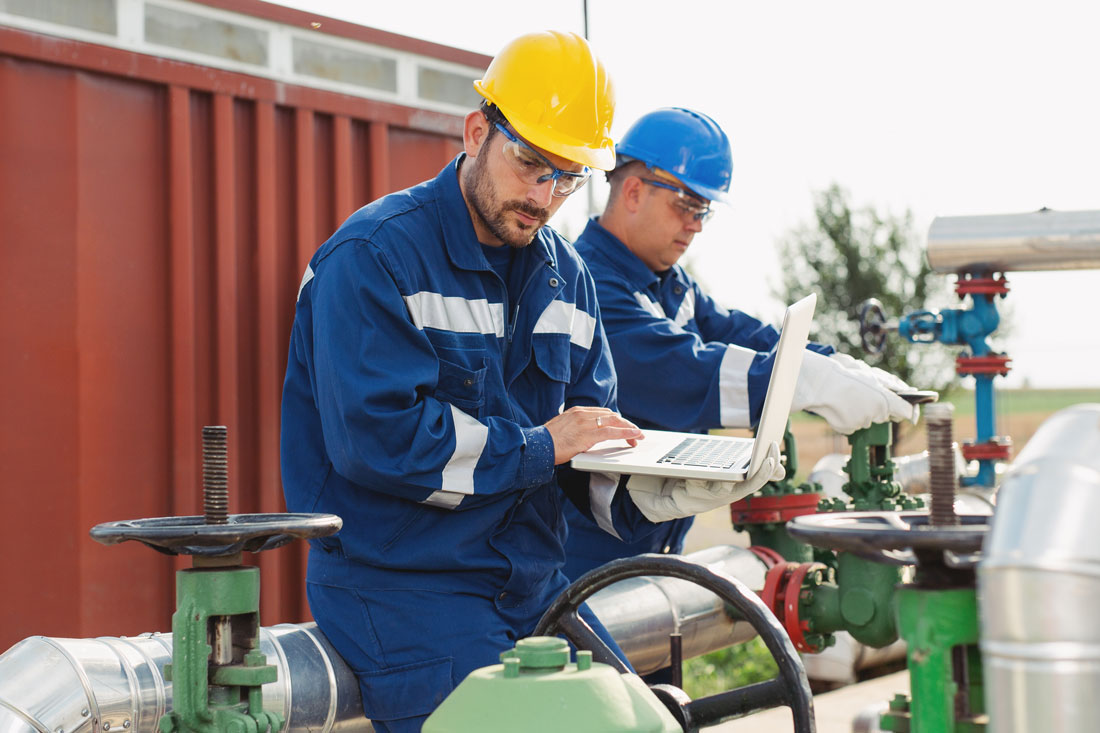 Two engineers working inside oil and gas refinery