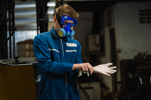 Factory worker preparing to work with hazardous materials.