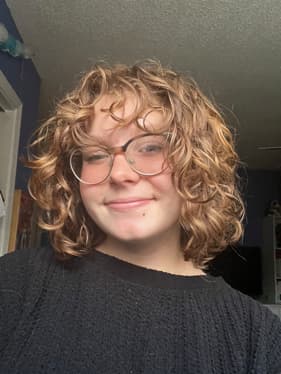 A person with curly hairDescription automatically generated with low confidence