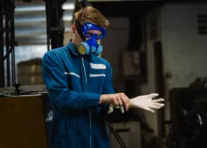 Factory worker preparing to work with hazardous materials.